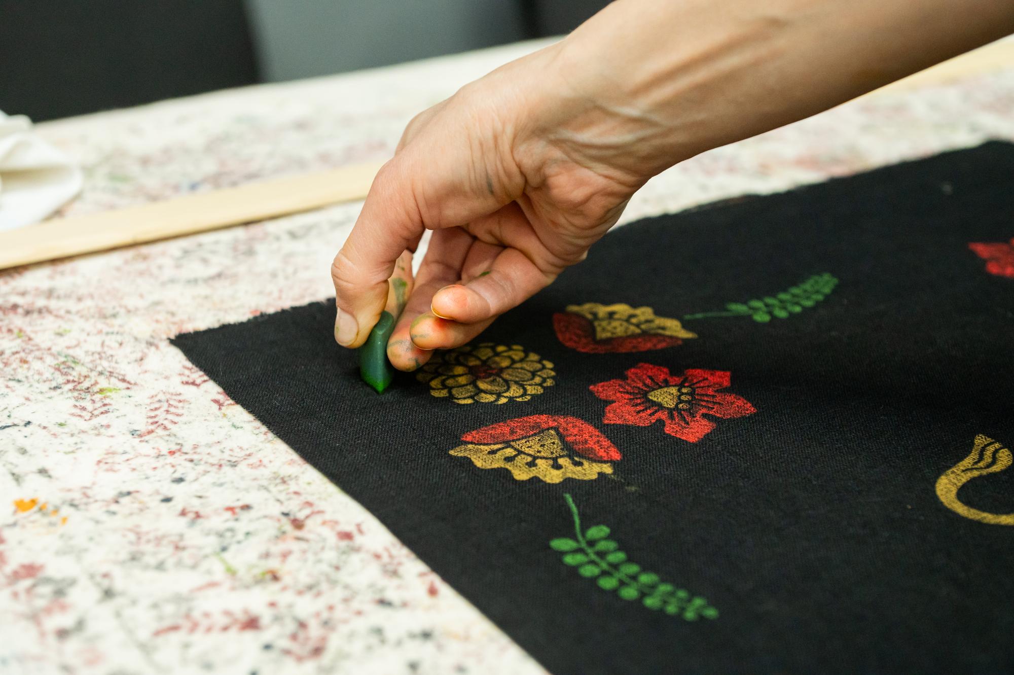 Hands finishing edge of embroidered patch
